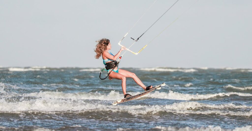 Woman enjoying kitesurfing in the ocean with strong winds and waves, showcasing skill and adventure.