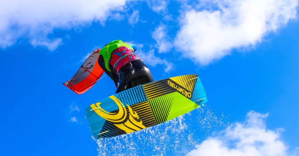 Dynamic action of a kitesurfer performing a high jump with water splashes against a bright blue sky.