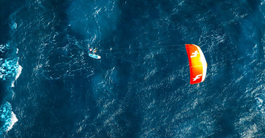 Kitesurfer gliding above blue ocean waves in Bacong, Central Visayas, Philippines.